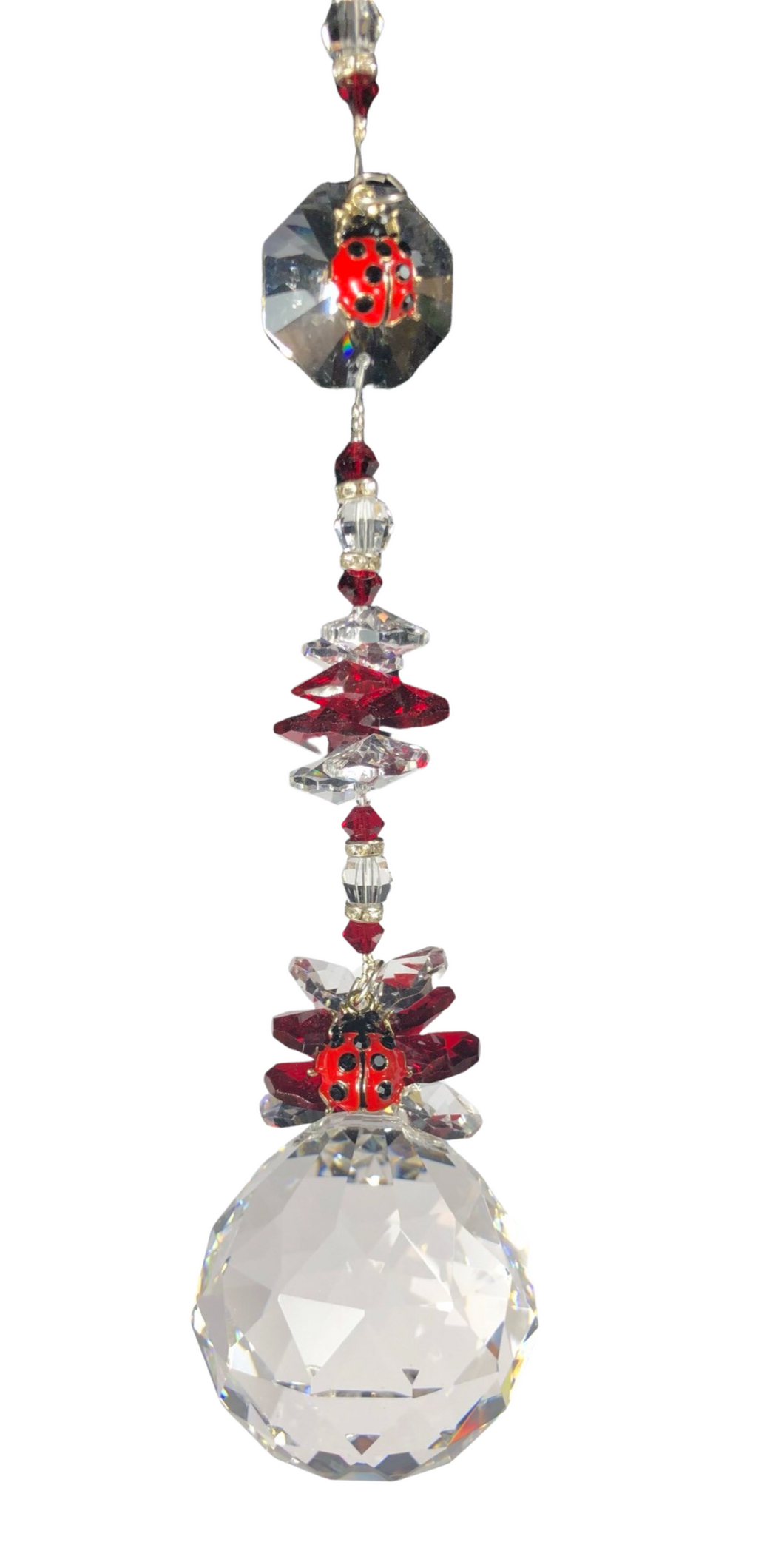 Crystal ball suncatcher which is decorated with a Lady Bugs and Garnet