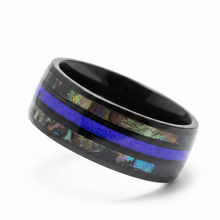 Load image into Gallery viewer, A black stainless steel ring band featuring a vibrant blue stripe and a central iridescent inlay with shimmering green, gold, and blue tones, shown on a clean white background.