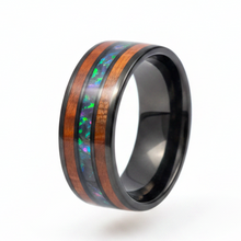 Load image into Gallery viewer, A black stainless steel band ring featuring a polished inlay of reddish-brown wood and a vibrant iridescent opal strip, shown on a clean white background.