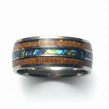 Load image into Gallery viewer, A polished band ring featuring a wood grain inlay flanked by silver-colored metal borders and a central iridescent abalone shell inlay, shown on a white background.