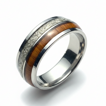 Load image into Gallery viewer, A polished stainless steel band ring featuring a central inlay of warm brown wood and a textured silver pattern design, shown on a clean white background.