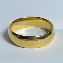 Load image into Gallery viewer, A classic yellow gold stainless steel band ring with a smooth, polished finish, photographed on a neutral light gray background.
