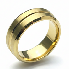Load image into Gallery viewer, A polished gold  stainless steel band ring with a brushed finish on the outer shoulders and a beveled edge, shown on a clean white background.
