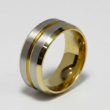 Load image into Gallery viewer, A two-tone stainless steel band ring with a brushed silver outer band and polished gold accents, photographed on a clean white background.
