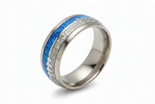 Load image into Gallery viewer, A polished silver-toned band ring featuring a vibrant blue inlay with a textured silver pattern running along the top edge, set against a clean white background.
