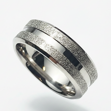 Load image into Gallery viewer, A silver-toned metal ring band with two parallel textured channels and a polished center stripe, shown on a clean light gray background.
