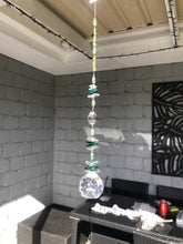 Load and play video in Gallery viewer, This large 50mm crystal ball suncatcher is decorated with crystal and peridot
