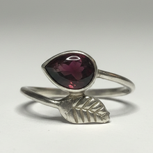Load image into Gallery viewer, A sterling silver ring with a garnet gemstone, displayed on a white surface.
