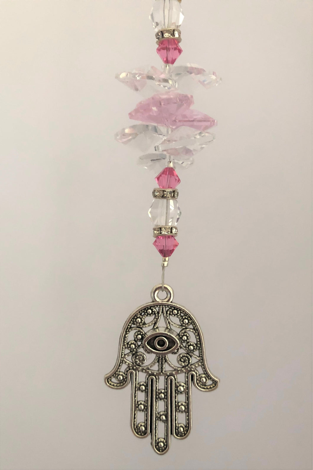 This beautiful Hand of Fatima suncatcher which is decorated with crystals and Rose Quartz