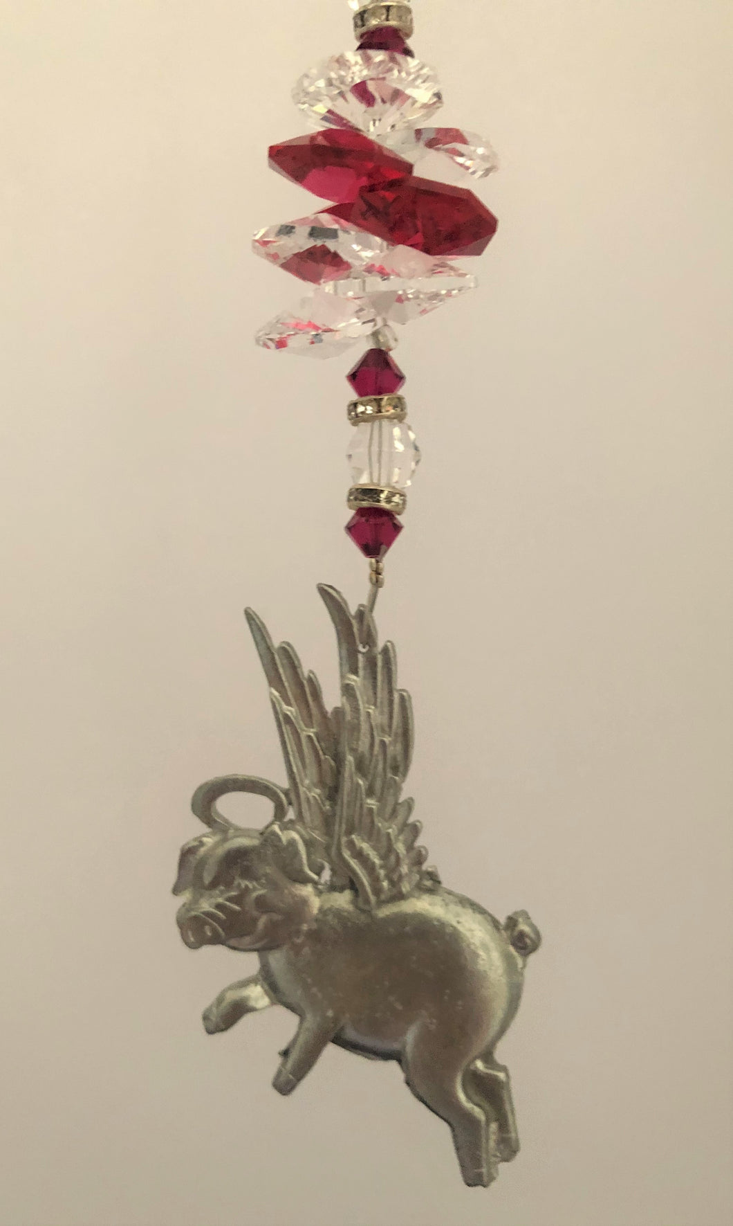 This beautiful Pig Flying suncatcher which is decorated with  crystals and Garnet