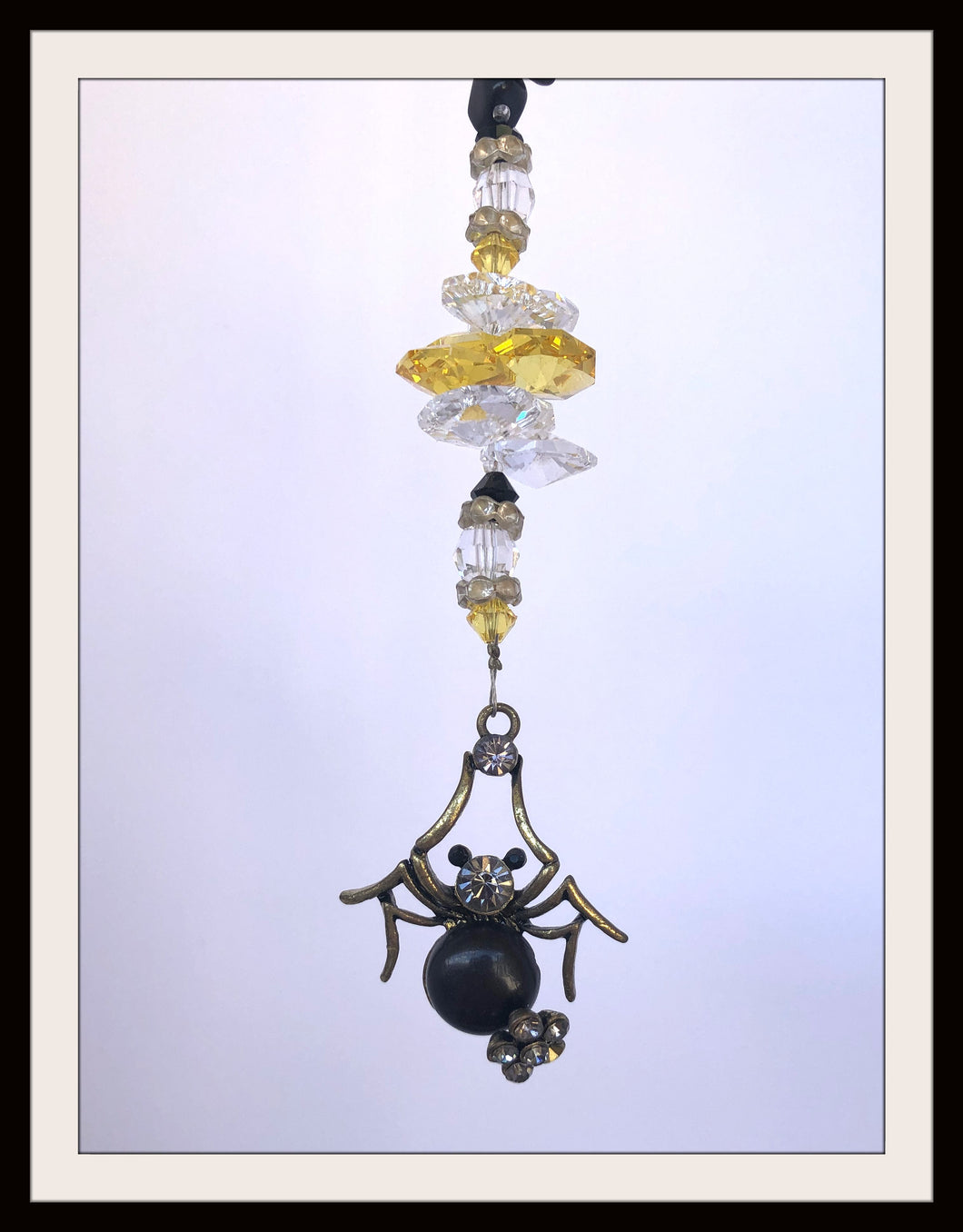This beautiful Spider Black suncatcher which is decorated with crystals and Snowflake Obsidian